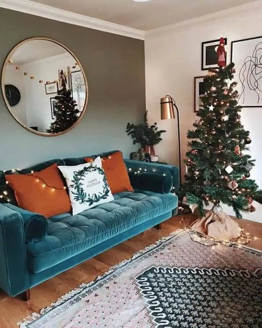 Holiday-themed living room with a teal sofa, terracotta pillows, and festive decor.