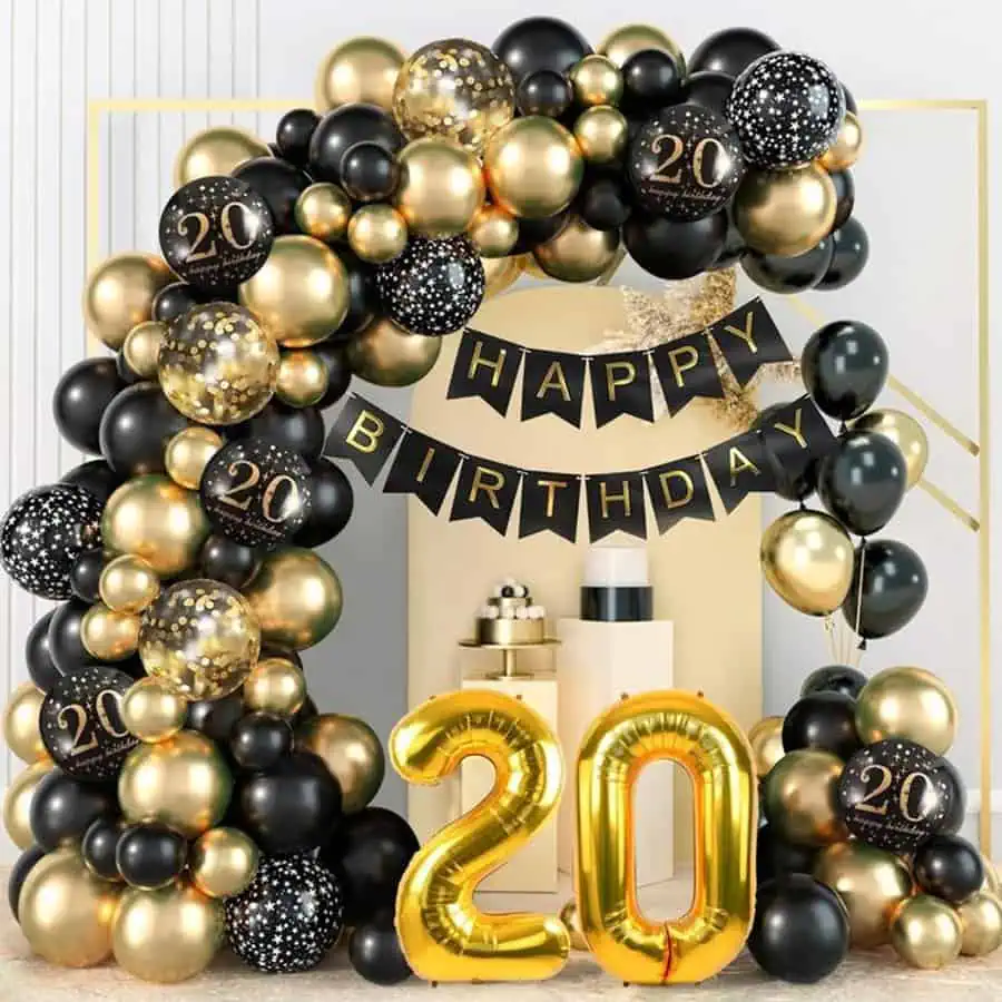 Black and gold "20th birthday" balloon arch with matching decor and a golden "20" centerpiece.