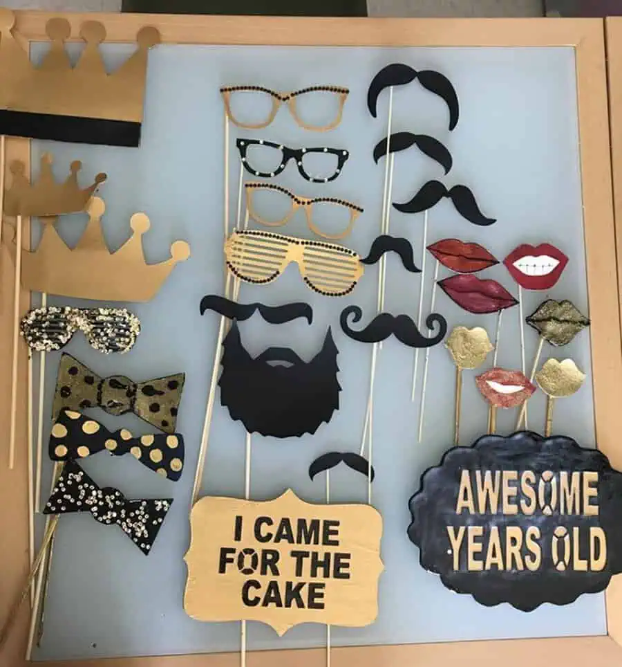 Photo booth props with crowns, glasses, mustaches, and fun birthday signs for a 20th celebration.