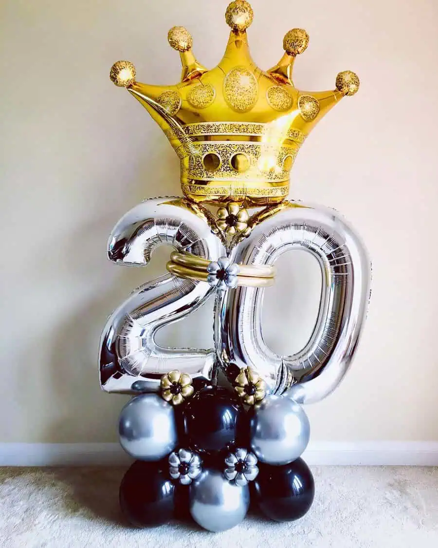 Gold crown and silver "20" balloon arrangement with black and silver base balloons.