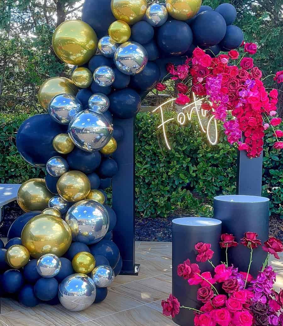 Modern 40th birthday decor with black, gold, and silver balloons, neon "Forty" sign, and pink roses.