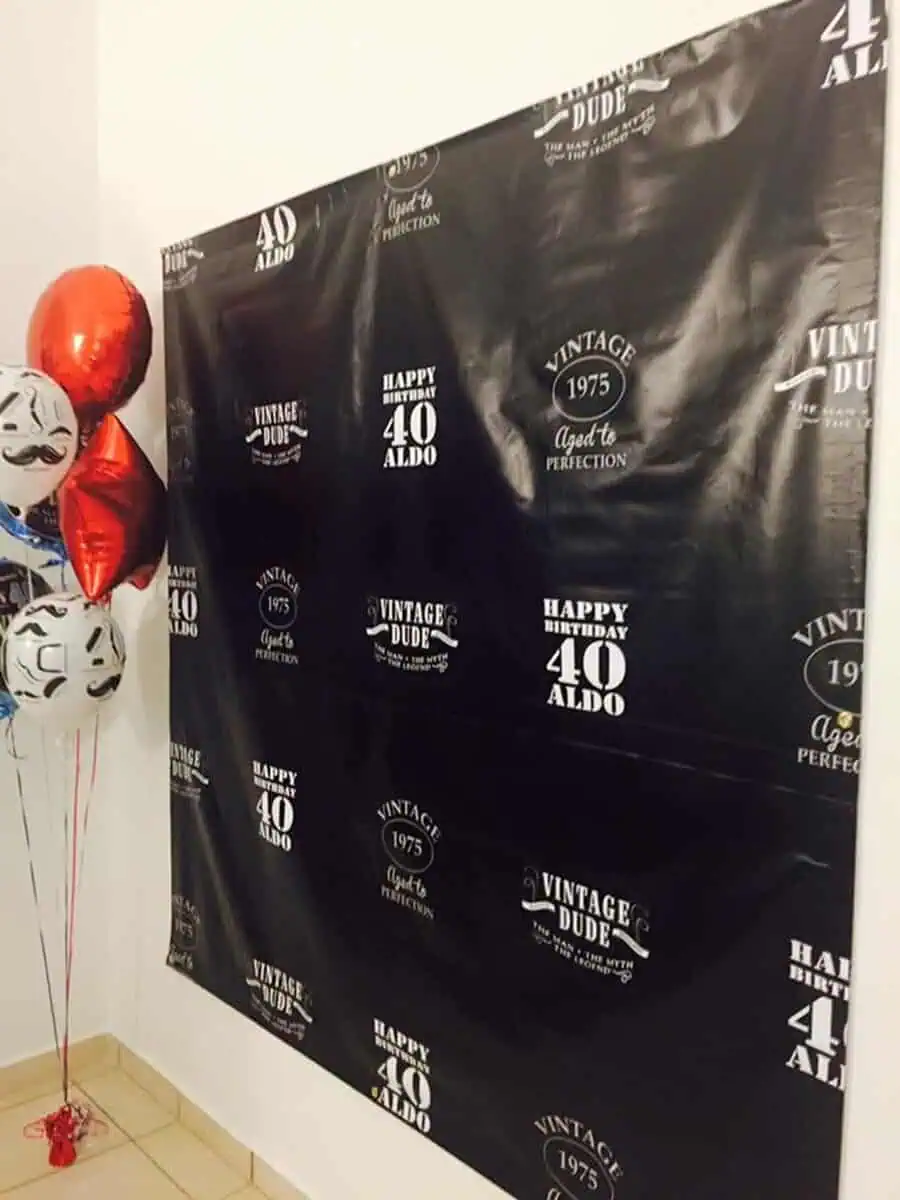 "Vintage Dude" themed 40th birthday backdrop with balloons for a stylish celebration.