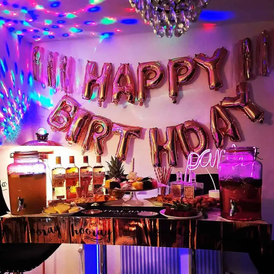 Vibrant 40th birthday setup with metallic balloons, party lights, and a stylish snack bar.