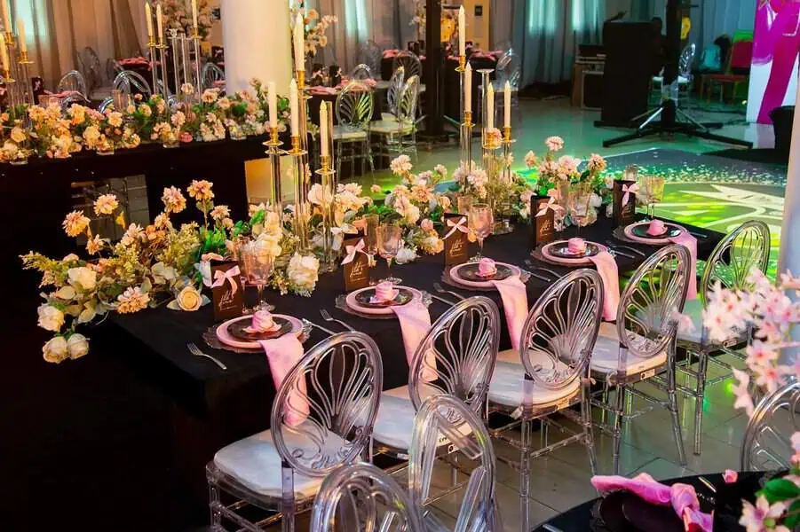 Sophisticated 40th birthday table setup with floral arrangements, pink details, and candles.