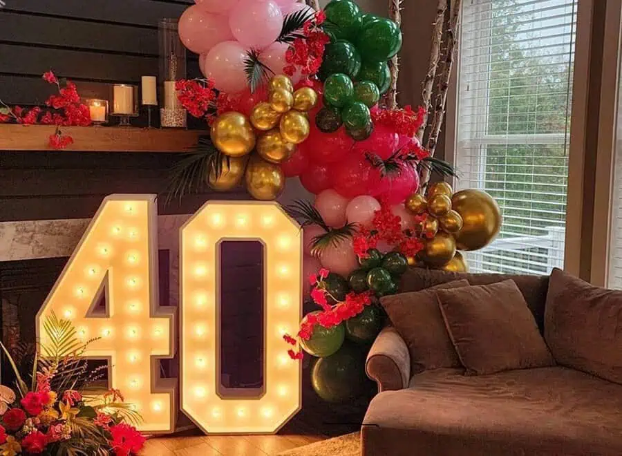 Vibrant 40th birthday setup with light-up numbers, colorful balloons, and floral accents.