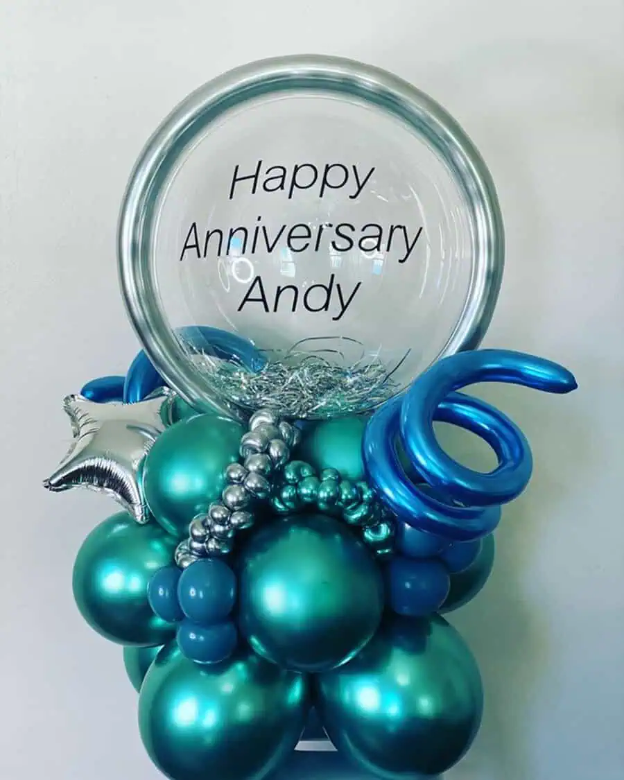 Personalized anniversary balloon display in teal and silver with "Happy Anniversary Andy" text.