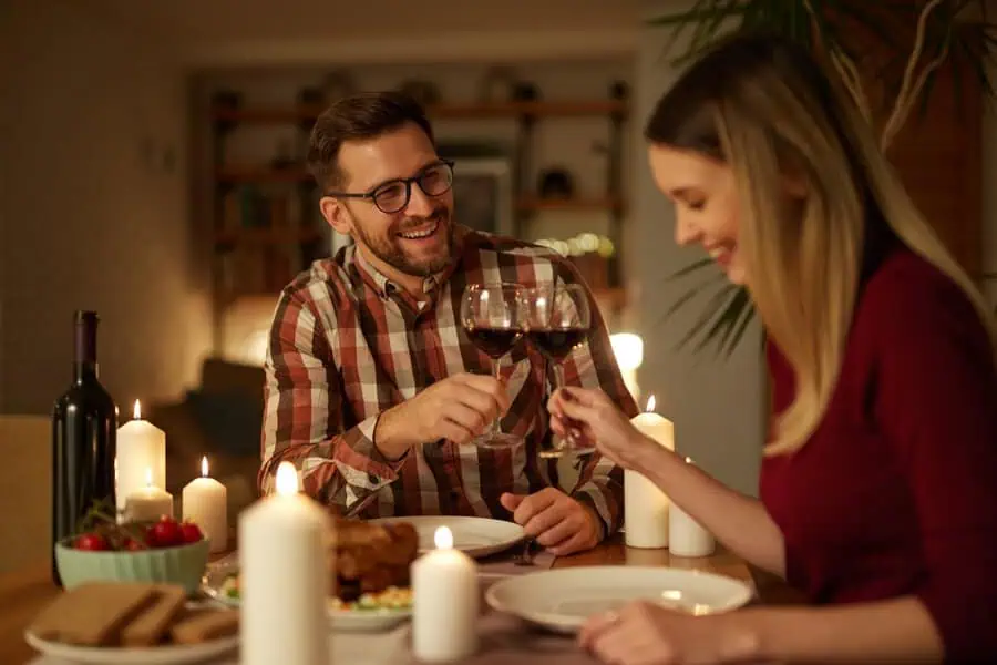 Couple celebrating their anniversary with a romantic candlelit dinner and wine.