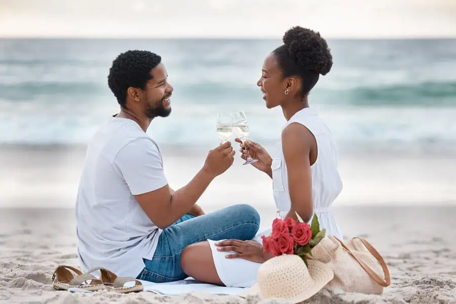 Romantic beachside anniversary idea for couples with wine and roses.