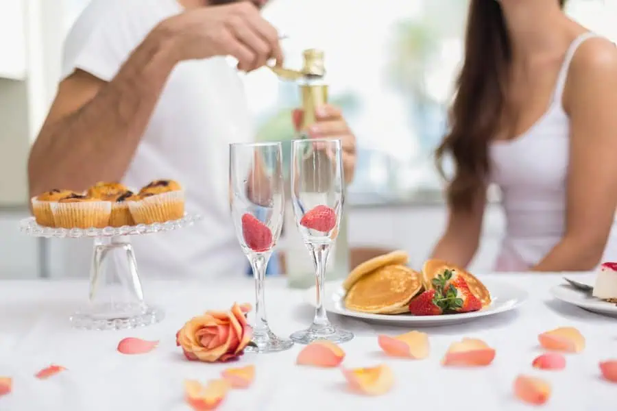 A romantic anniversary breakfast with champagne and sweet treats.