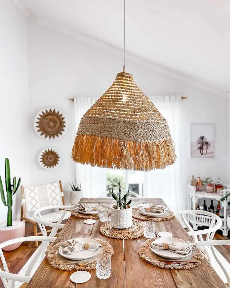 Beach-inspired dining table with coastal decor, woven pendant light, and natural accents.