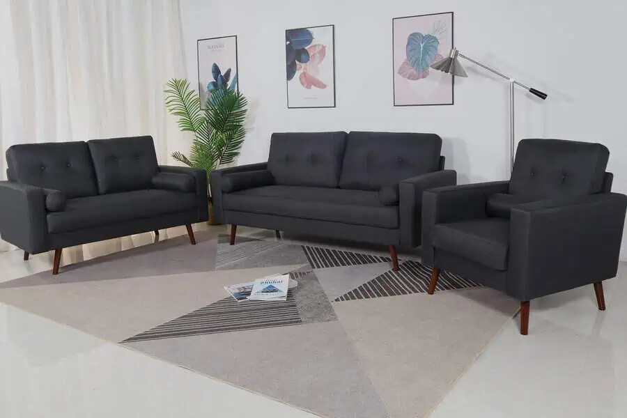 Dark grey mid-century sofa set with geometric rug, modern art, and minimal decor accents.