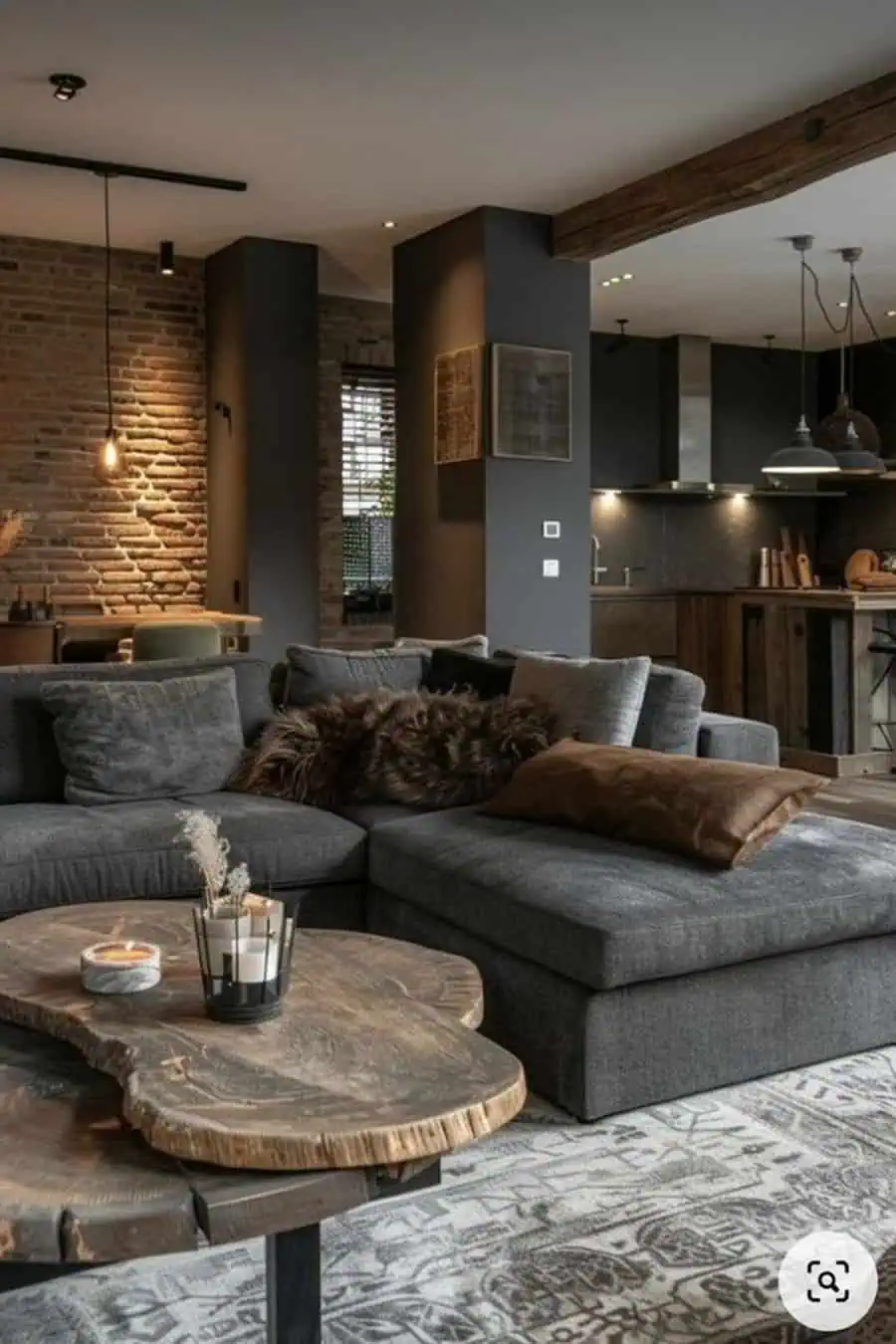 Dark grey sectional sofa with rustic wood coffee table, exposed brick wall, and industrial decor accents.