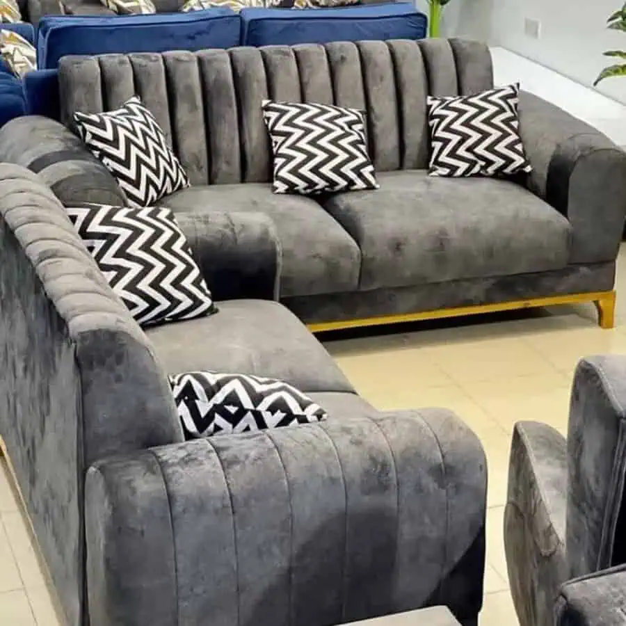 Modern dark grey sofa set with bold black-and-white zigzag cushions.