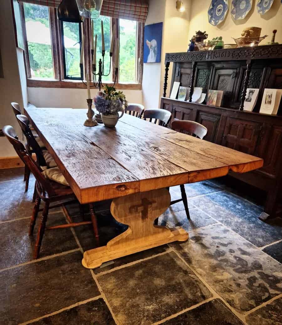 Rustic wooden dining table with vintage chairs in a cozy farmhouse-style room.