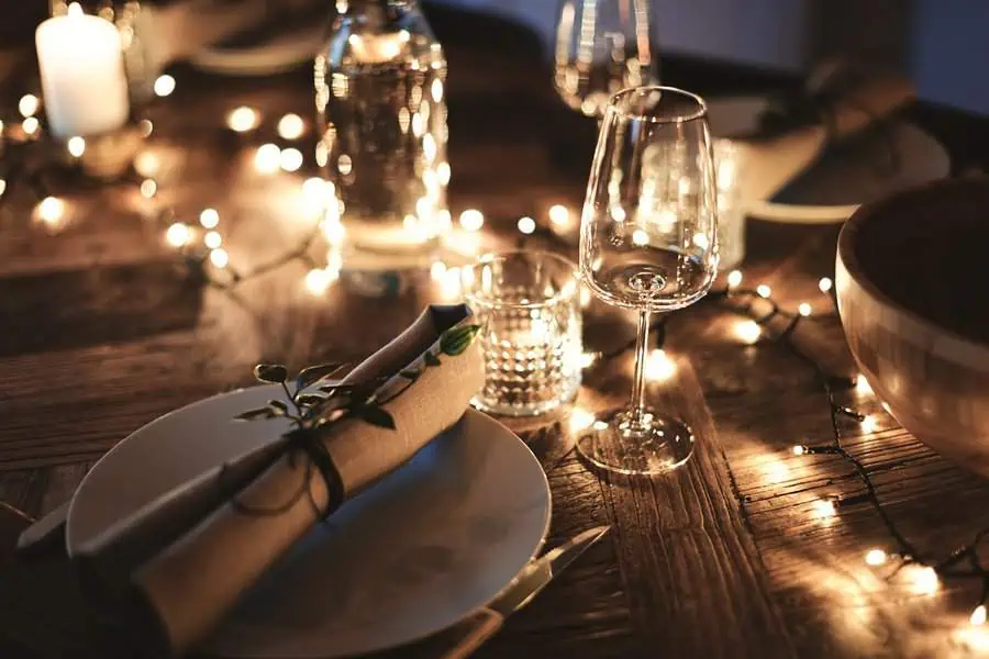 Dining table decor with string lights, natural accents, and personalized homey touches.