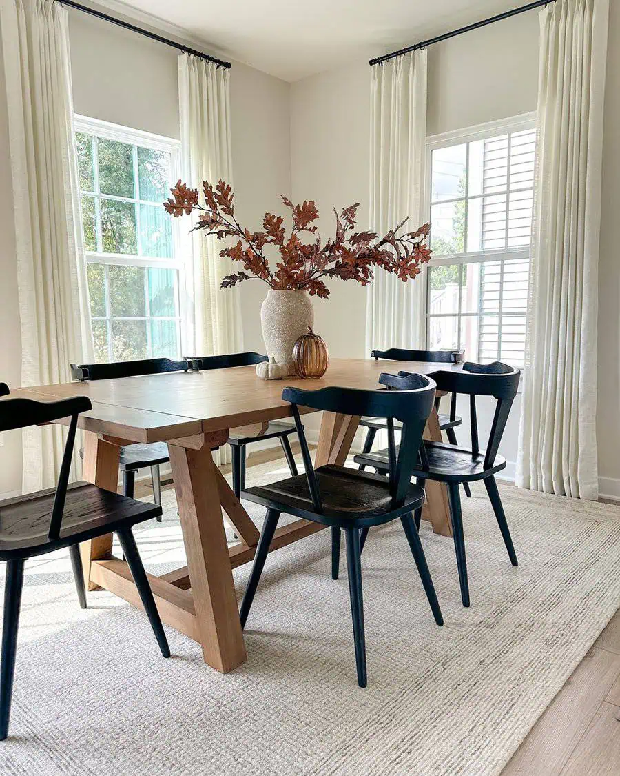 Dining table decor with a stunning centerpiece of autumn branches in a textured vase.