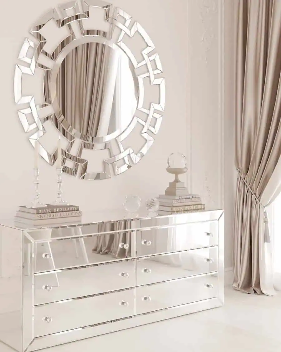 Luxurious mirrored dresser with decorative round feng shui mirror and elegant decor.