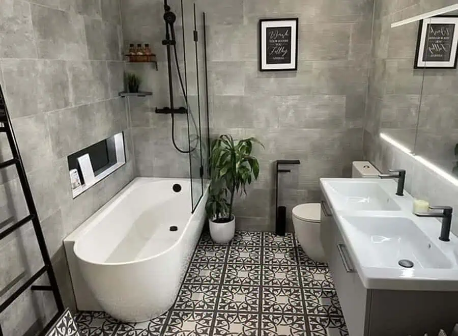 Modern grey bathroom with patterned ceramic floor tiles, a freestanding tub, and potted plant.