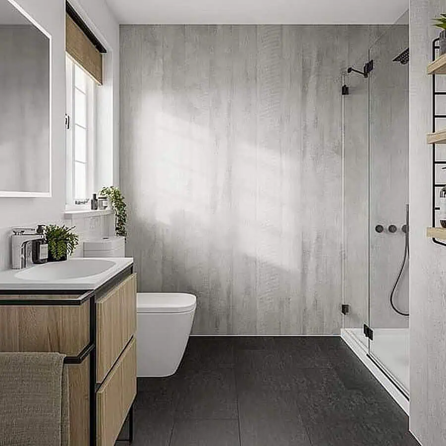 Minimalist grey bathroom with dark floor tiles, wood vanity, and glass-enclosed shower.