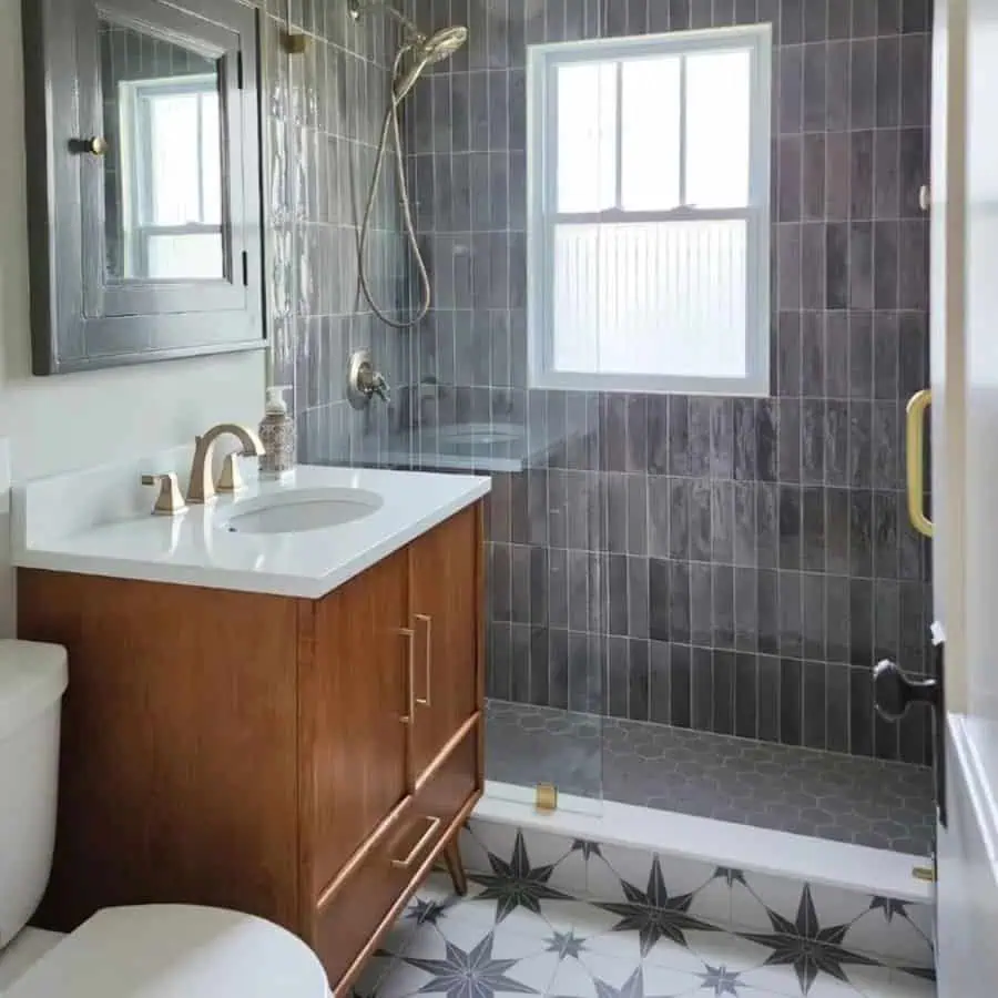 Bathroom with grey subway wall tiles, star-patterned floor tiles, and a wooden vanity.