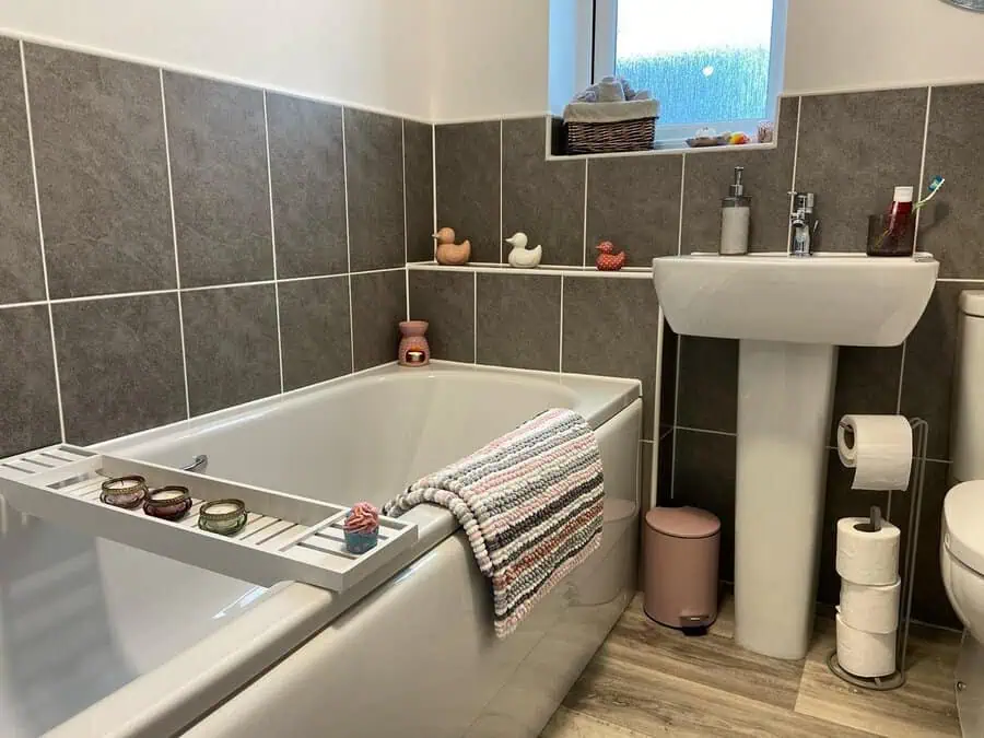 Bathroom with grey and white floor tiles, matching wall tiles, and a clean, modern design.