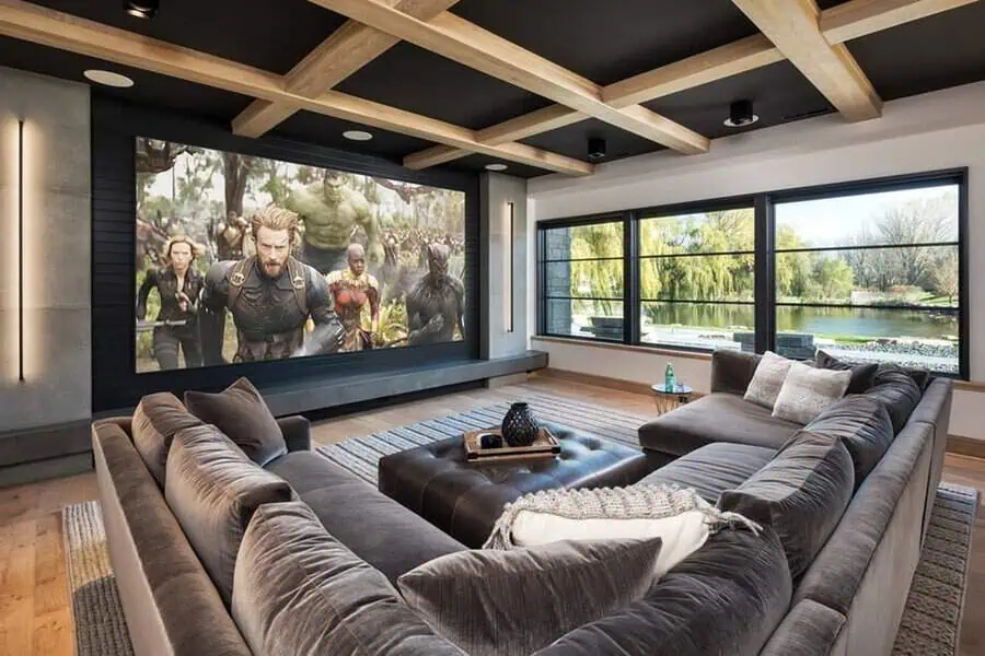 Home theater with a cozy dark grey sofa and a large screen for a cinematic feel.