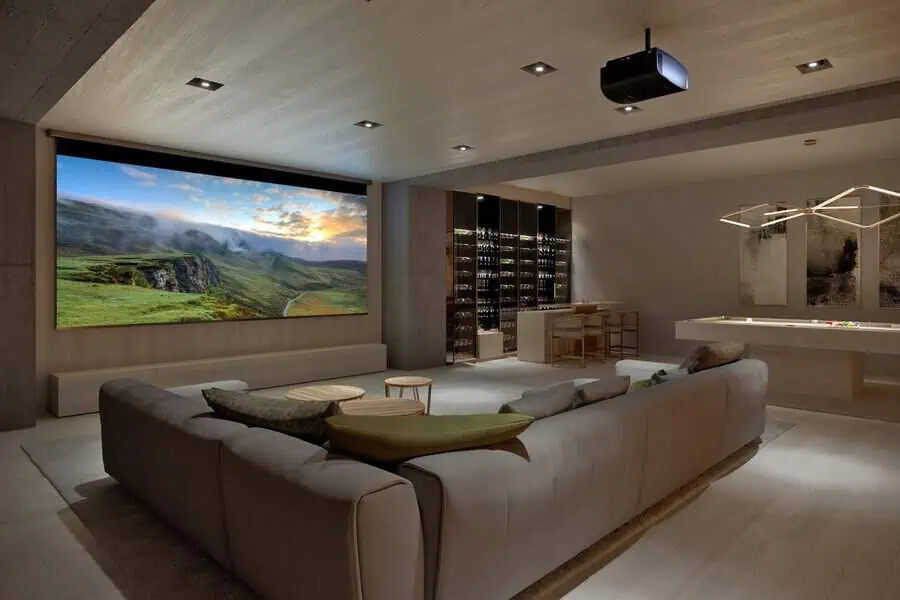 Modern home theater with a plush sofa, a wide screen, and a built-in bar for ultimate relaxation.