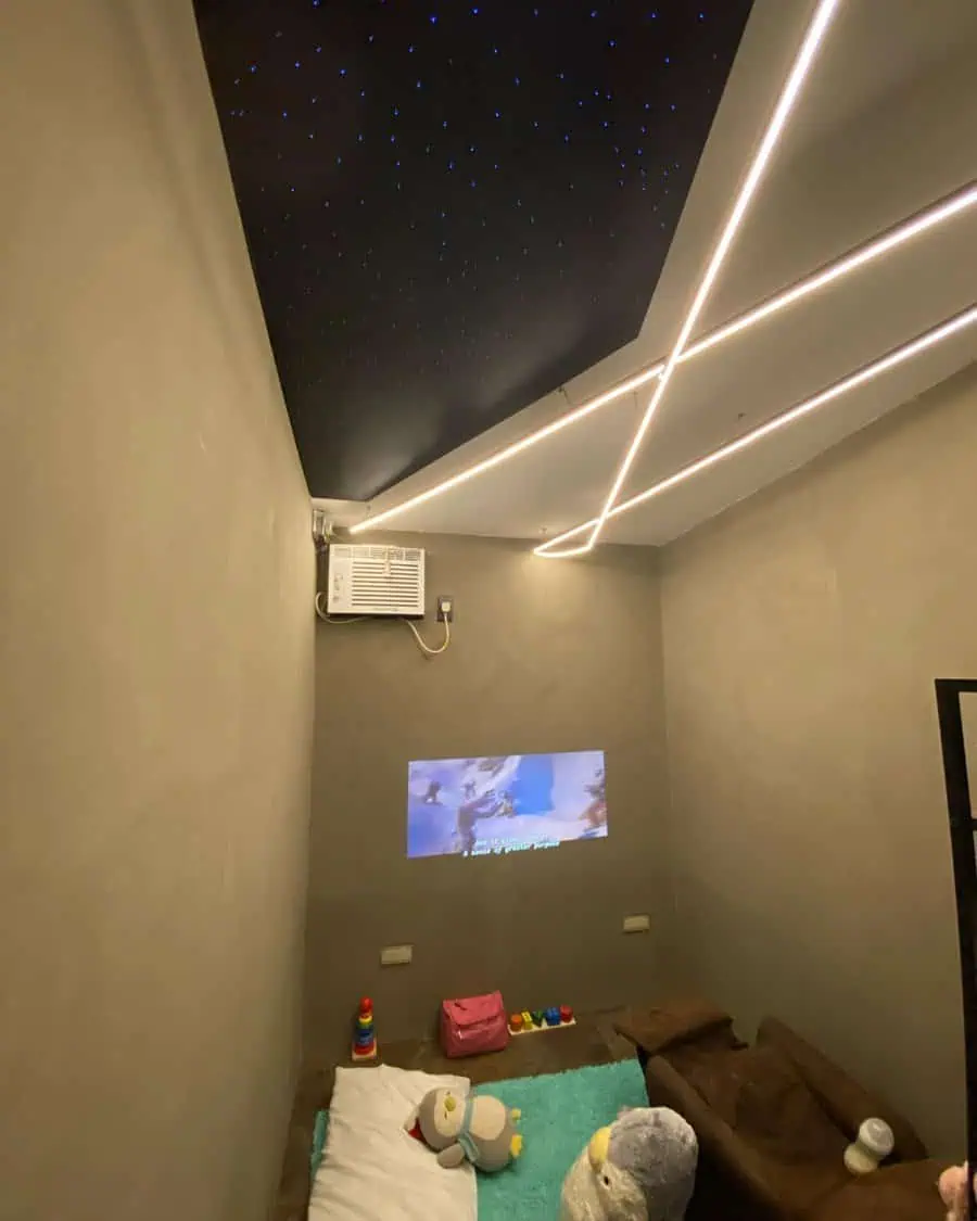 Cozy mini-theater with a starlit ceiling, simple seating, and a wall projector for small spaces.