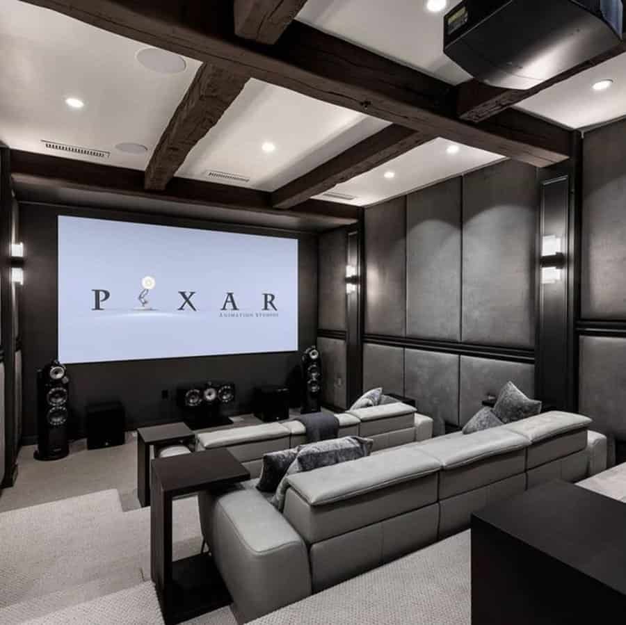 Modern home theater with sleek leather seating, dark wood beams, and acoustic wall panels for a cinematic experience.