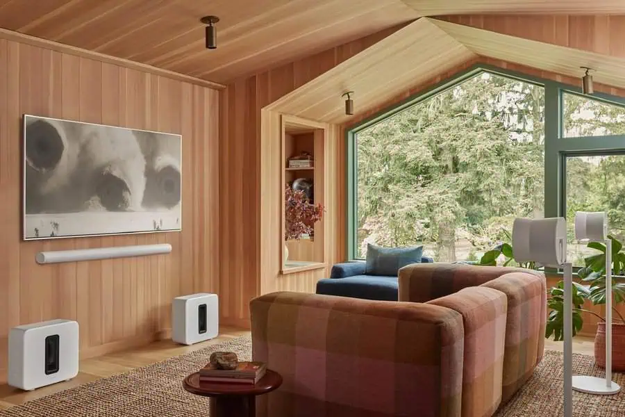 Cozy home theater with wood-paneled walls, colorful seating, and a scenic window view.