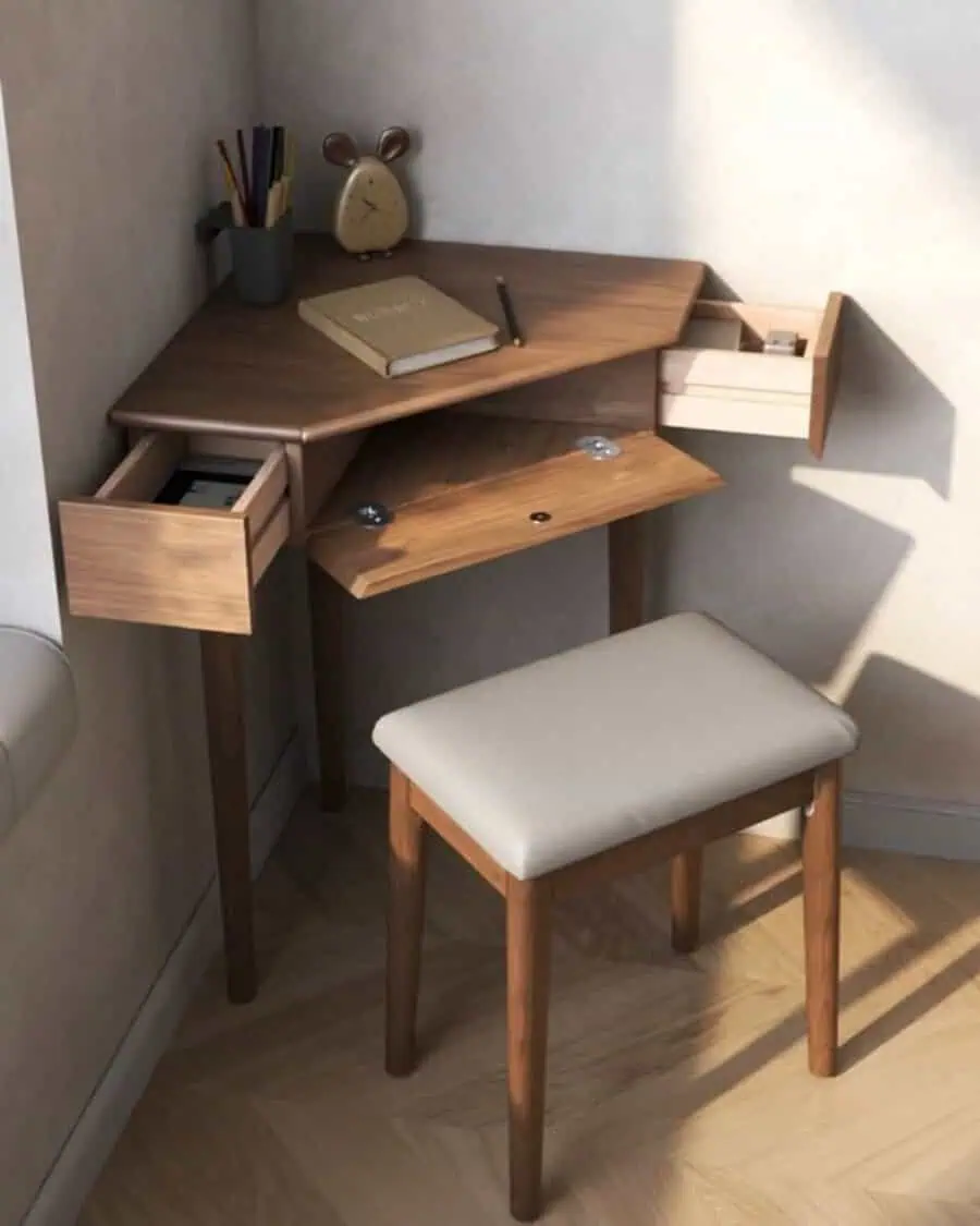 Living room corner with a small wooden desk, drawers, stool, clock, and stationery.