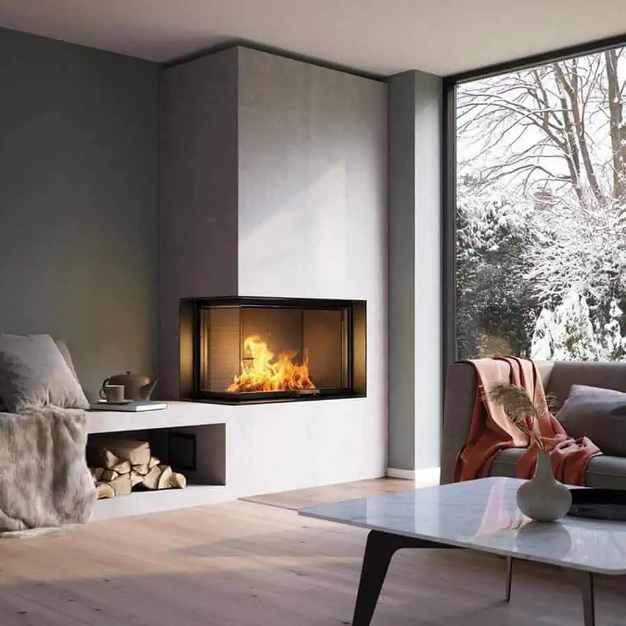 Modern living room corner with a fireplace, large window, cozy seating, and a snowy outdoor view.