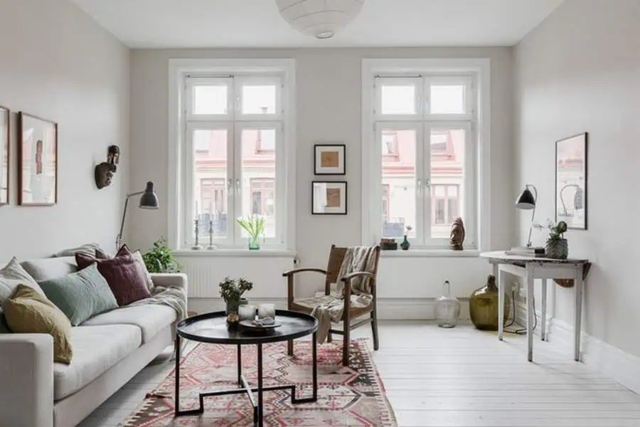 Scandinavian living room with natural light, colorful accents, and minimalist furniture.