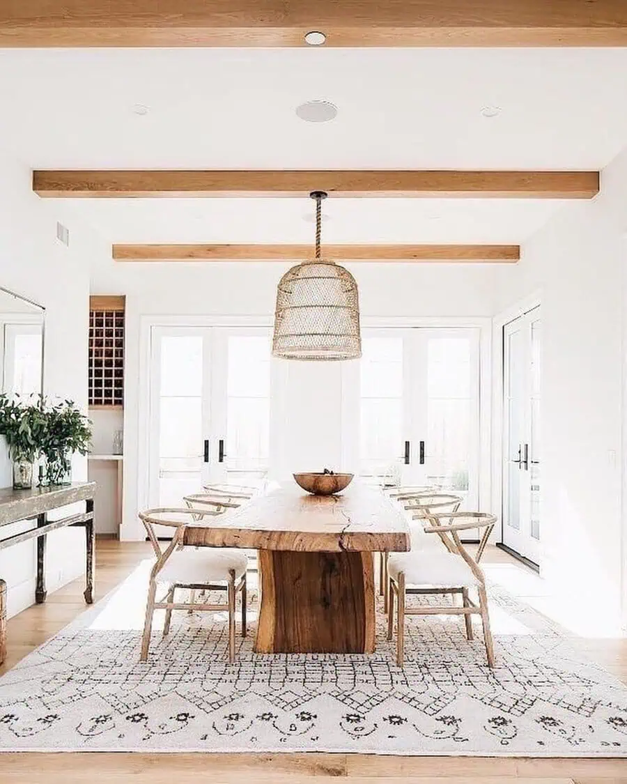 Scandinavian dining room with a rustic wooden table, woven chairs, and natural light.