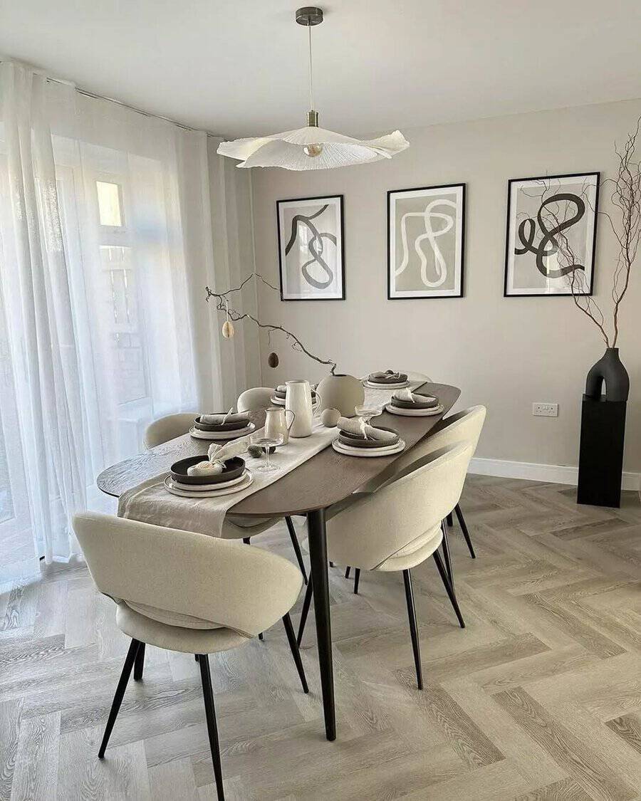 Scandinavian dining room with modern decor, abstract wall art, and minimalist table setting.