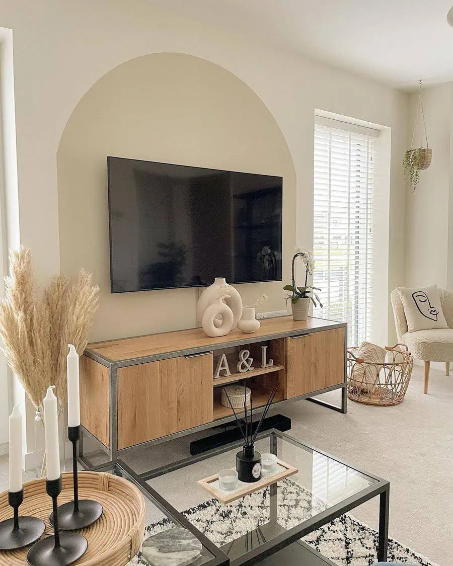 Modern Scandinavian living room with wooden TV stand, glass table, and neutral decor accents.