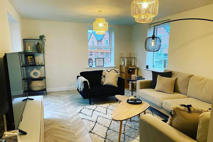 Scandinavian living room with cozy seating, patterned rug, and modern pendant lighting.