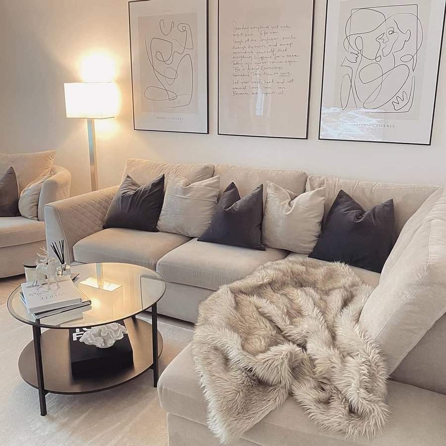 Scandinavian living room with beige sofa, abstract wall art, and a cozy faux fur throw.