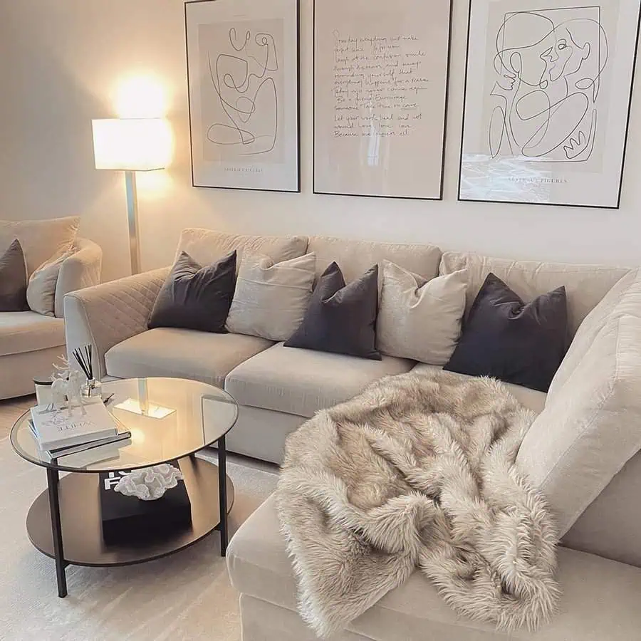 Scandinavian living room with beige sofa, abstract wall art, and a cozy faux fur throw.