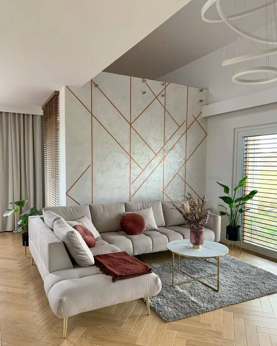 Modern Scandinavian living room with geometric accent wall, cozy sofa, and natural light.