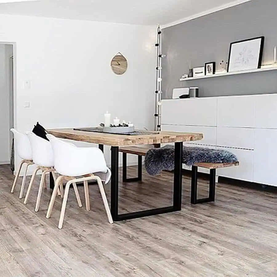 Scandinavian dining area with wooden table, white chairs, and minimalist decor.