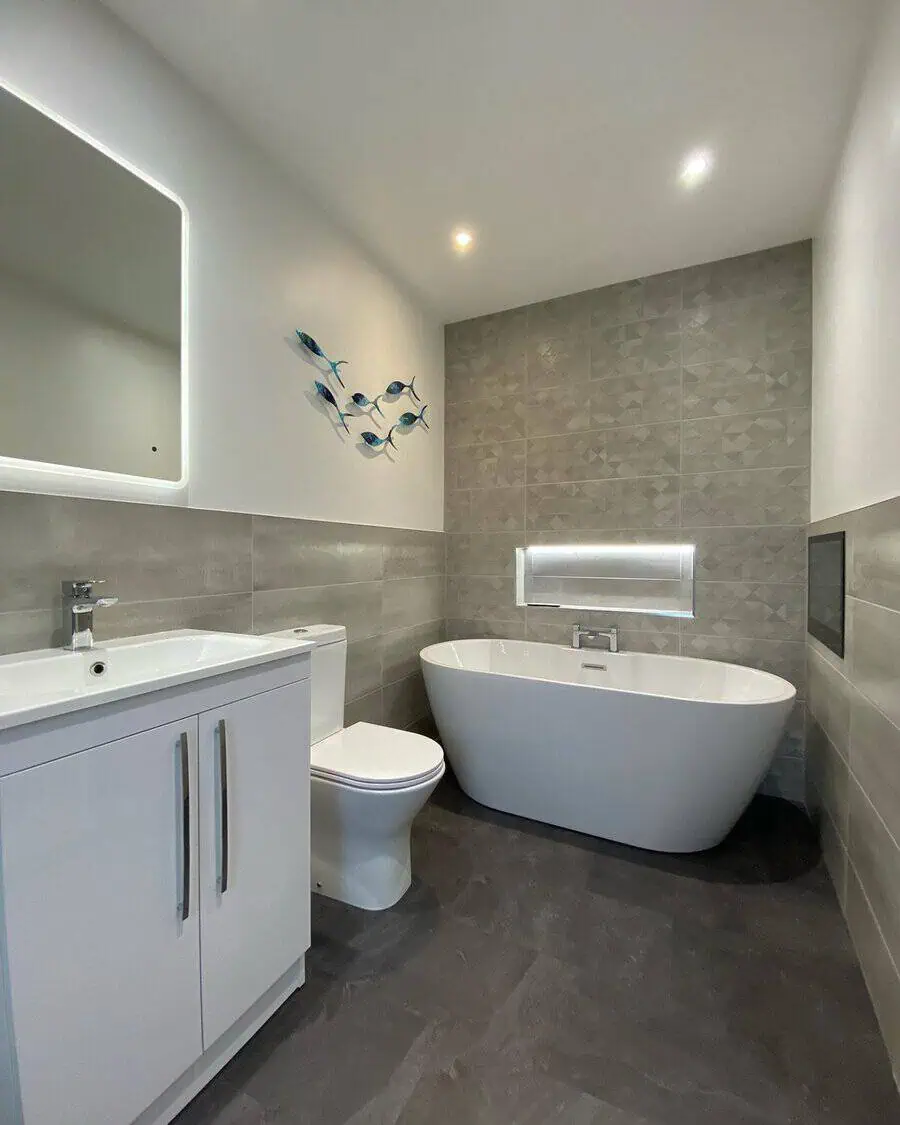 Slate grey bathroom floor tile with freestanding tub, modern white vanity, and decorative wall art.