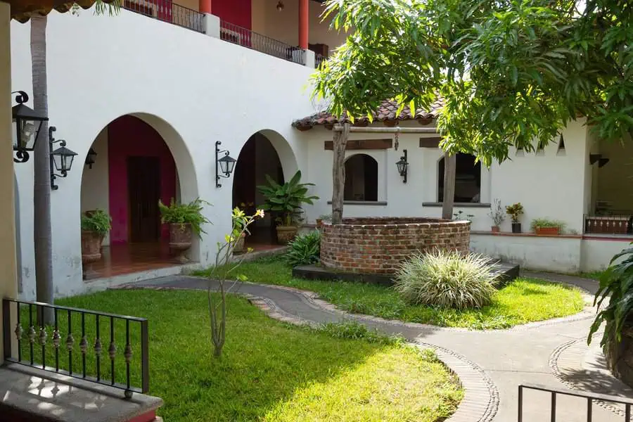 Spanish-style courtyard with arched walkways, a red tile roof, and a central brick well.