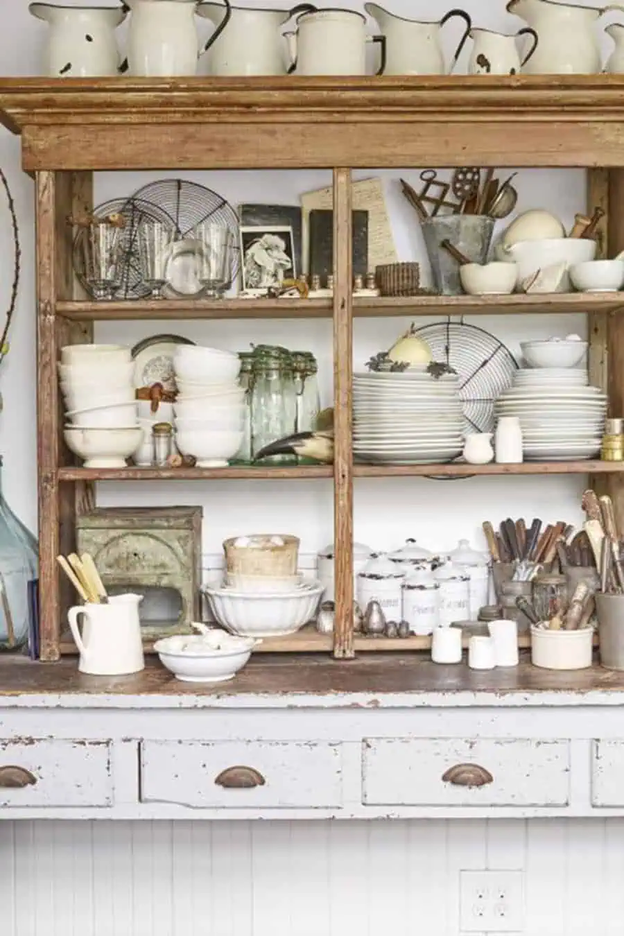 Rustic open shelving with vintage dishes, glass jars, and farmhouse-inspired kitchen decor.