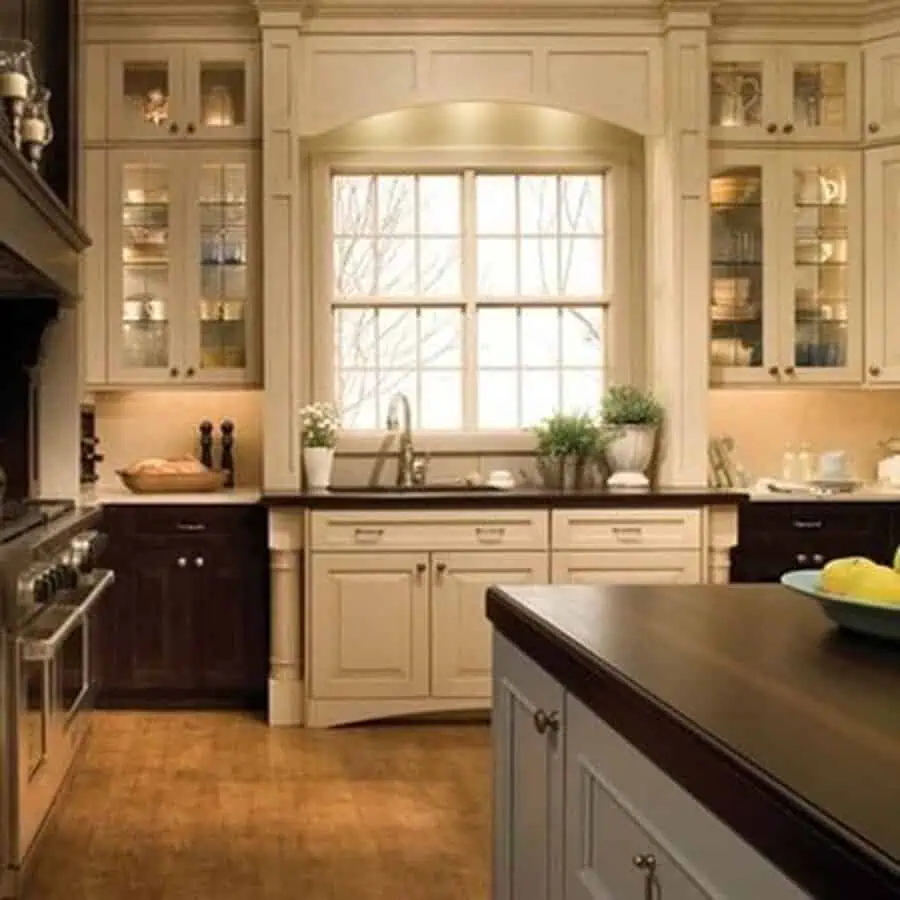 Traditional kitchen with cream and dark wood cabinets, glass accents, and a large window.