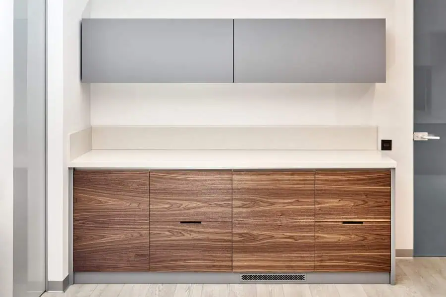 Minimalist two-tone design with sleek grey upper cabinets and natural wood lower cabinets for a modern, clean look.