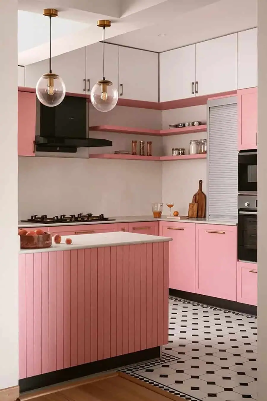 A stylish kitchen featuring soft pink lower cabinets, white upper cabinets, open pink shelves, and bold patterned flooring.