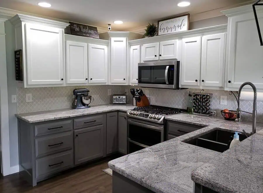 Traditional kitchen with white upper cabinets, gray lower cabinets, and granite countertops.