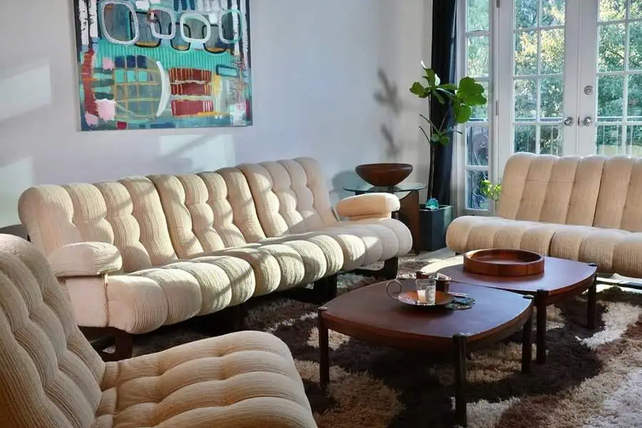 1960s contemporary living room with tufted sofas, wooden tables, and retro-inspired decor.