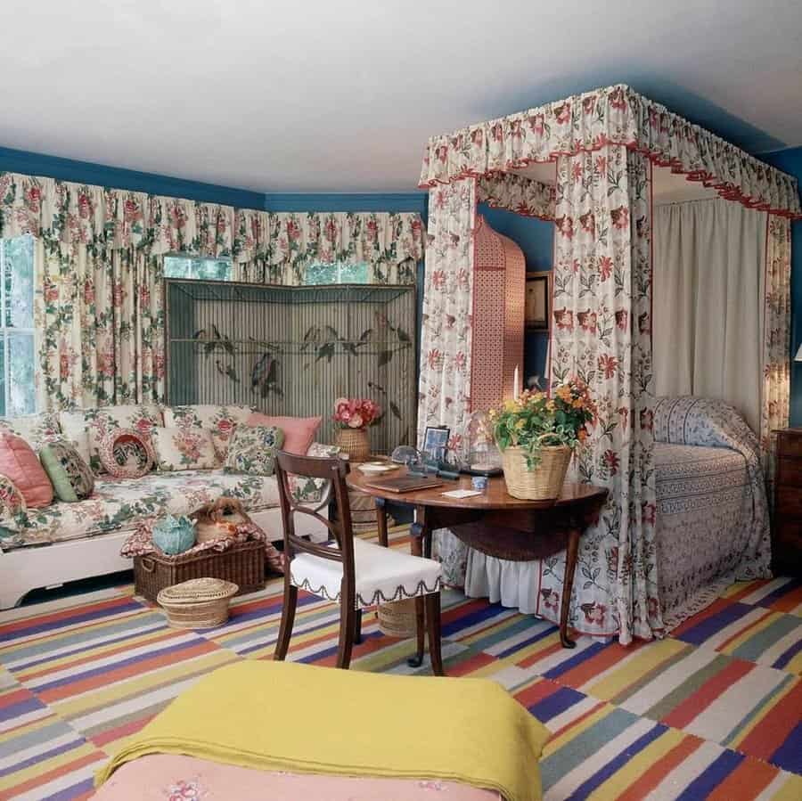 1960s-inspired bedroom with floral patterns, canopy bed, vintage furniture, and a colorful striped rug.